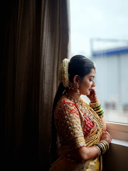 A quiet moment of reflection. This profile view shows the intricate embroidery work on the sleeve of the bridal blouse.