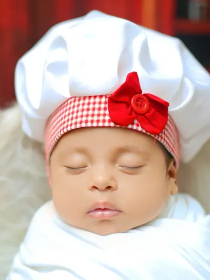 A beautifully lit close-up of the newborn's face during the chef-themed shoot.