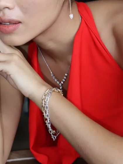 A closer view of the layered look, featuring the Y-shaped diamond necklace paired with a modern link bracelet in mixed metals.