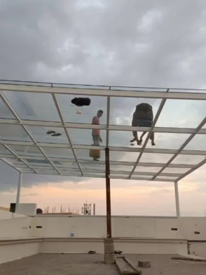This image captures our team during the installation of a toughened glass roof on a white MS pergola frame. This option allows for maximum natural light while offering protection from rain, perfect for enjoying the sky view in any weather.