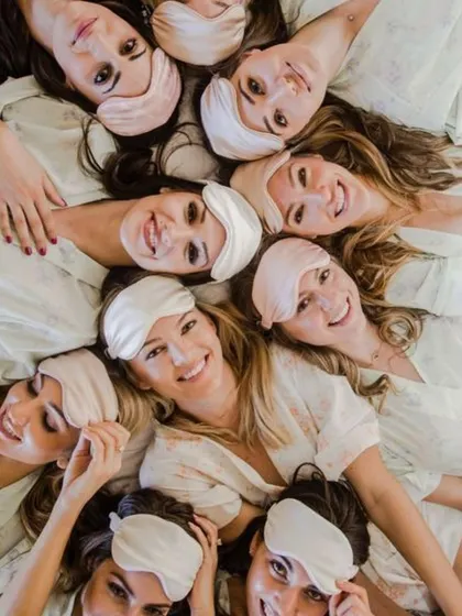 A cozy and cute bachelorette photoshoot idea. The bride and her bridesmaids in matching pajamas and eye masks make for an adorable group photo.