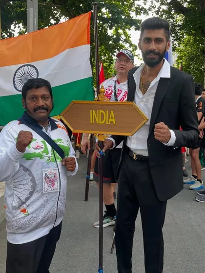 Standing with the Indian flag and a senior official at the international games. My goal is to put Indian fighters on the world map.