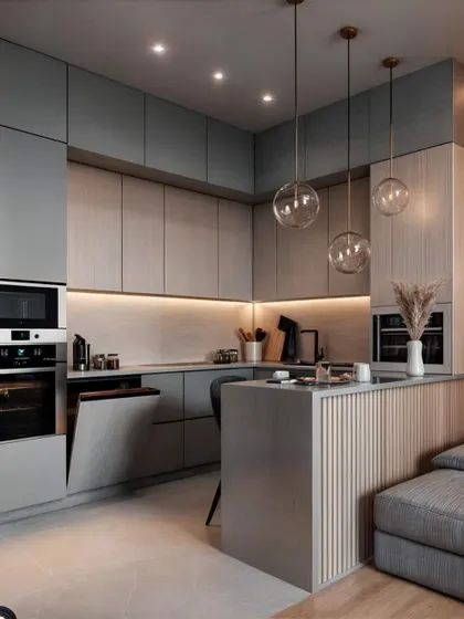 This compact kitchen and living area shows how to integrate different functions seamlessly. The kitchen features modern grey cabinets and a small island that separates it from the cozy sofa area.