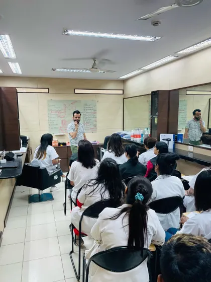 Our trainer explaining the science behind hair treatments to a full class. Understanding the 'why' is just as important as knowing the 'how' in professional hairdressing.