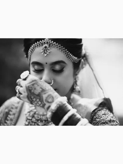 An emotional black and white close-up of the bride, her hand to her face.