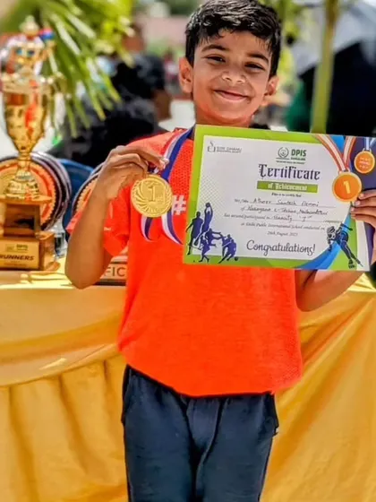 The smile of a winner. A young skater from our academy proudly displays his first-place certificate and gold medal after a competition.