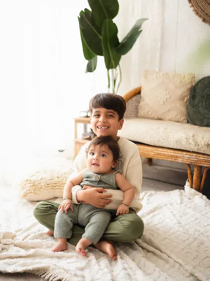 Big brother holding his baby sibling, a sweet and protective moment.