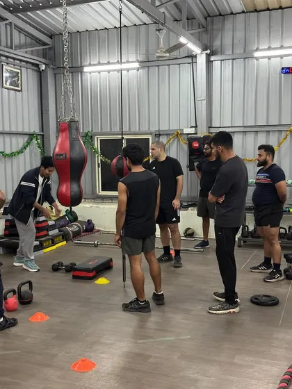A senior trainer briefing the group before a strength and conditioning session. Clear demonstration and instruction are key.