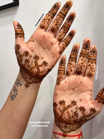 This delicate design features a branching lotus pattern on the palms, with simple bands on the fingers. It's a great way to have beautiful mehendi that complements a small tattoo.