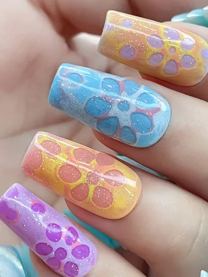 A close-up of the 3D floral bubble nails, showing the intricate patterns and the subtle shimmer of the glitter.