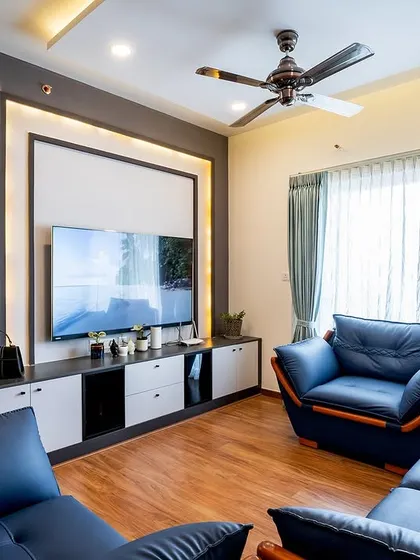The living room of the 'Blackwood' apartment, designed for Uma and her family. The space combines bold blue sofas with warm wood flooring and a sleek, modern TV unit.