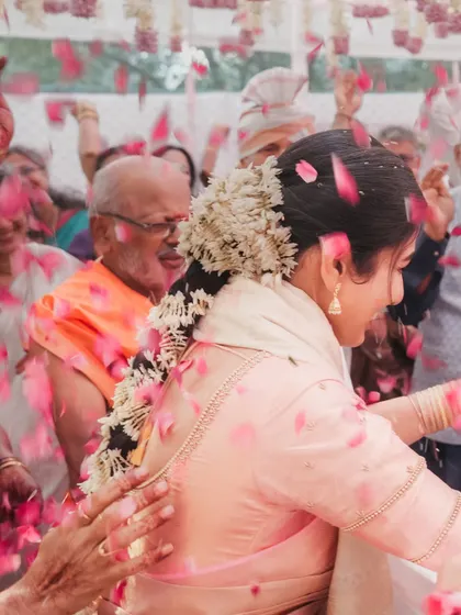 The bride is surrounded by a shower of petals, a moment of pure celebration. Our candid photography freezes these fleeting, joyful moments in time.