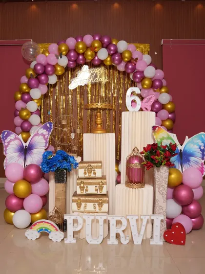 A glamorous butterfly theme with a gold shimmer backdrop and large butterfly cutouts.