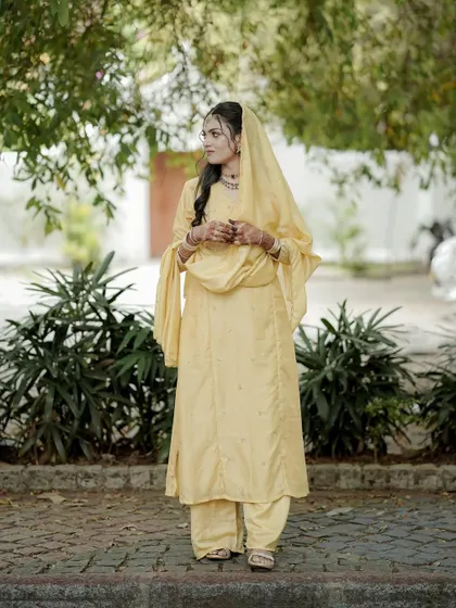 A duplicate of a beautiful outdoor portrait of the bride, her yellow outfit glowing in the natural light.