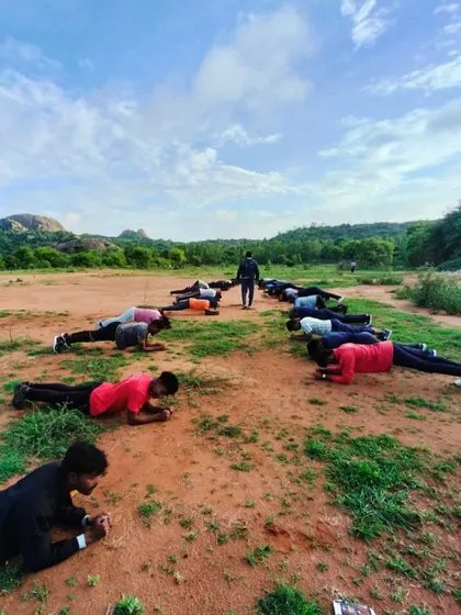 A group of participants engages in a morning workout against the scenic Ramanagara landscape.