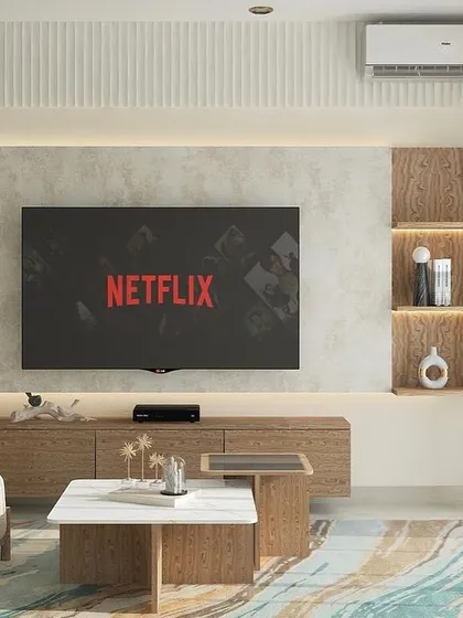 We designed this family lounge with a focus on clean aesthetics and function. The floating TV console is paired with backlit open shelves for displaying decor, all set against a subtly textured wall.