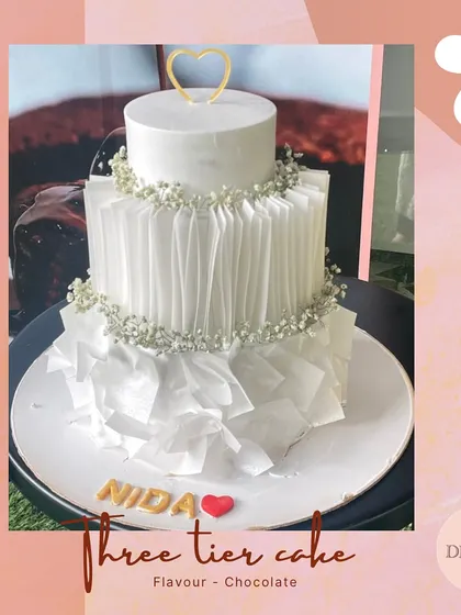 A modern masterpiece in white. This three-tier cake uses edible wafer paper to create artistic ruffles, offering a unique texture and a highly contemporary look for a stylish wedding.