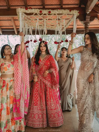 The bride's grand entrance under a beautiful 'phoolon ki chadar' held by her loved ones. This is a classic, emotional moment that I love to photograph.