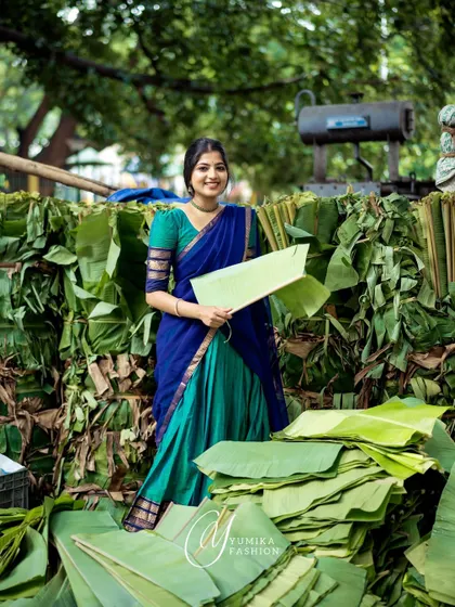 Modeling a Kanchi cotton half-saree in a market setting. The contrast between the traditional blue and green outfit and the everyday location creates a unique visual story.
