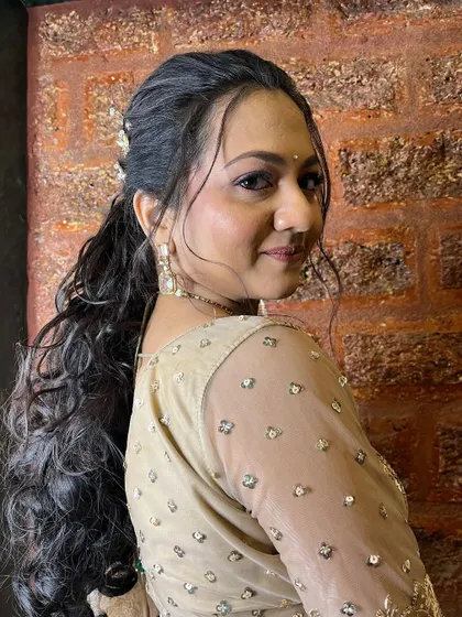 Kritika's sangeet look. A modern, chic ponytail with butterfly accessories paired with soft, glowing makeup.