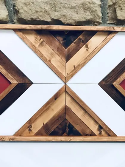 A close-up of the Aztec wood art, focusing on the geometric precision and the contrast between the painted and stained wood sections.