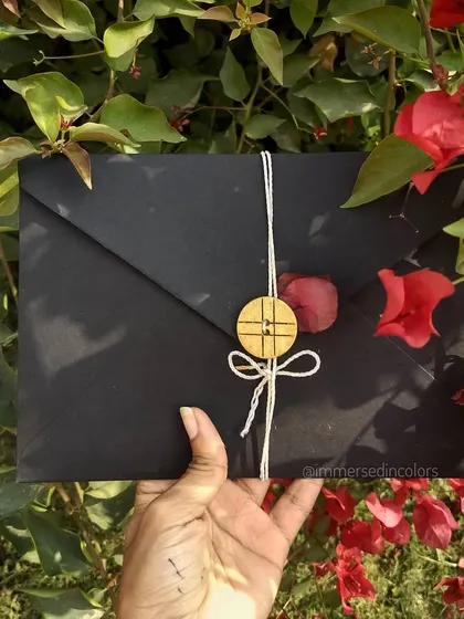 A handmade black envelope, tied with simple twine and a wooden button, holding a precious, handwritten message. The presentation is just as important as the letter itself.