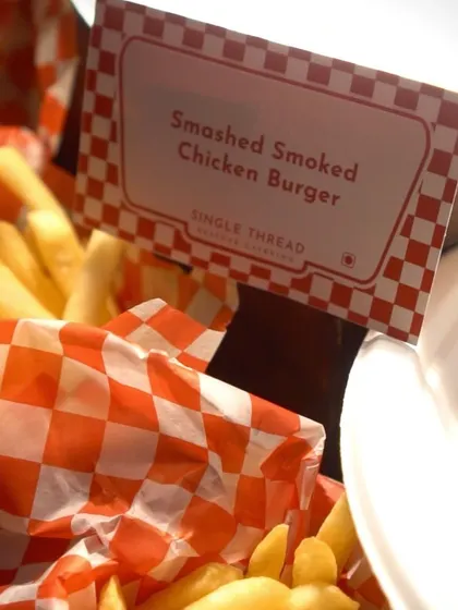 A close-up of the Smashed Smoked Chicken Burger menu card, showcasing the attention to detail in my themed live stations.