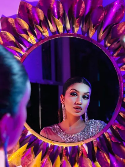 A creative shot using a mirror to reflect this glamorous look. The purple and gold lighting adds to the mood.