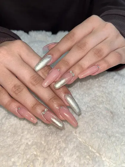 A long, coffin-shaped set with a nude base and silver chrome accent nails. This is a chic and modern look.