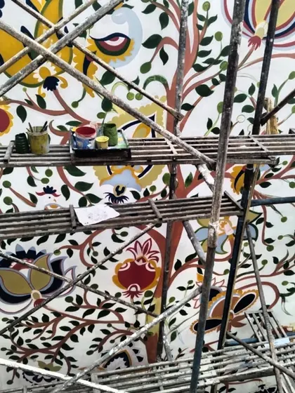 My paints and brushes resting on the scaffolding, with the beautiful Kalamkari mural in the background. This is my happy place.