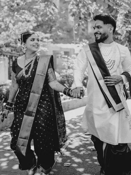 A happy, candid moment of the couple walking, captured in classic black and white. This style emphasizes their joyful expressions and the movement in the scene.