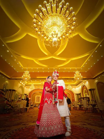 A classic pose under the chandelier, perfect for a wedding album cover.