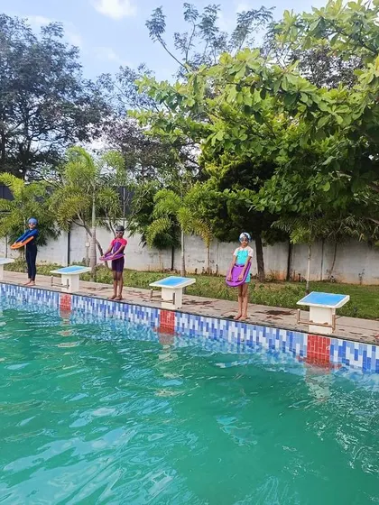 Students line up at the edge of our temperature-controlled swimming pool, ready for the start of an inter-house swimming competition.