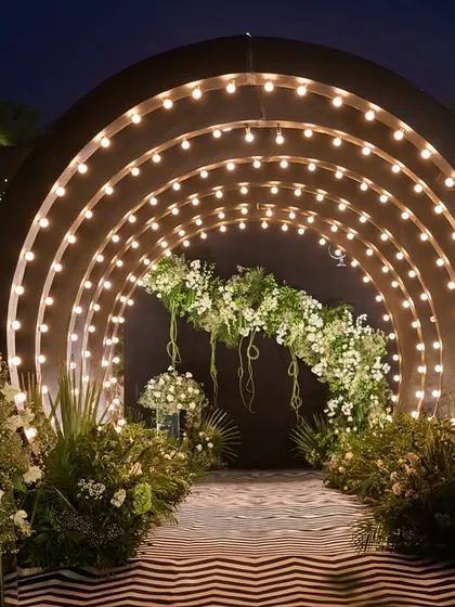 Your Sangeet entrance should be nothing short of dramatic. I designed this illuminated tunnel with a bold chevron-patterned floor and lush white florals to build excitement and welcome guests into a night of celebration.