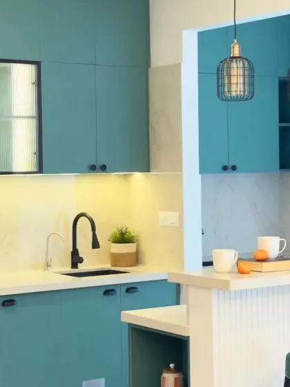 A detail shot of the teal blue kitchen, highlighting the black accent handles and fluted glass shutters. This combination creates a seamless blend of classic elegance and modern simplicity.