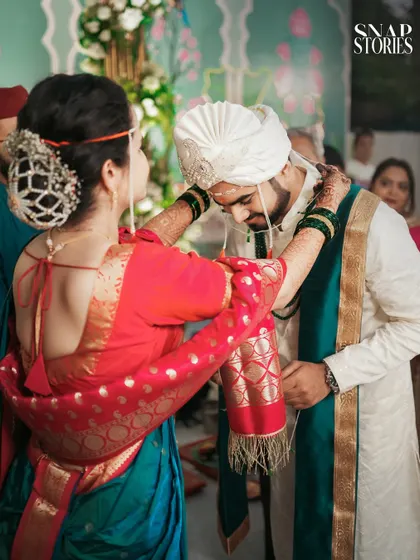 A tender moment as the bride adjusts the groom's attire. Our candid photography captures the small, caring gestures that reveal a couple's bond.
