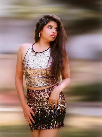 A vibrant and energetic portrait with a motion blur background. The gold sequin outfit shines, creating a glamorous and eye-catching look.