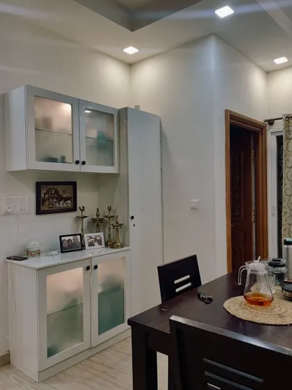 A functional crockery unit with frosted glass doors provides ample storage in the dining area. This piece is designed to be practical while maintaining a light and airy feel.