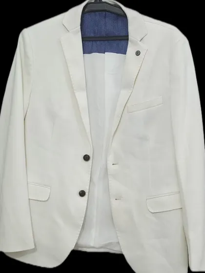 A versatile and classic off-white blazer for rent. This piece can be dressed up or down, making it perfect for a casual pre-wedding shoot or a semi-formal event.