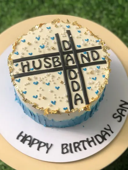 A top-down view of the "Husband" and "Dada" crossword cake.