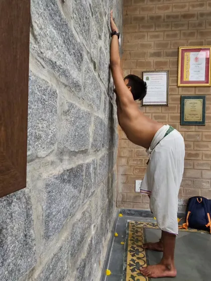 An intense Adavu session in progress. Here, a student is working on flexibility and posture, essential components for a strong Bharatanatyam dancer.