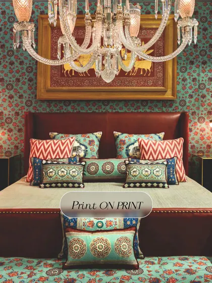 I believe in celebrating the art of 'more'. This bedroom showcases a maximalist approach, layering print on print with a bold, floral wallpaper that envelops the room in color and personality, creating a space that is vibrant and full of life.