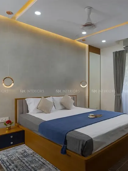 This bedroom combines a grey accent wall with warm wood tones for a sophisticated look. The hanging pendant lights and large clock add stylish details to the serene space.