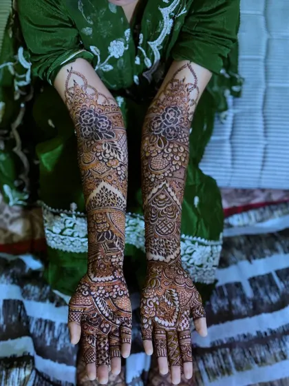 A full view of a bridal henna design on the hands and feet, showcasing the complete and coordinated look.