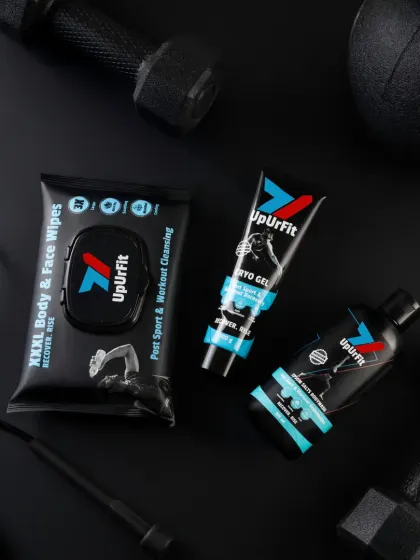 A dark and moody flatlay for UpUrFit's fitness products. The all-black background, rugged props, and dramatic lighting create a high-performance, energetic vibe that matches the brand's active tone.