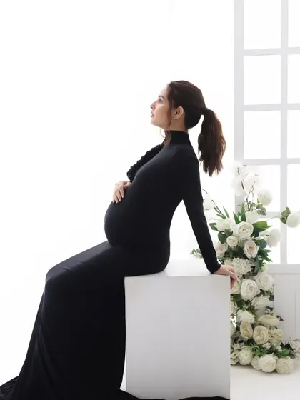 Elegance in simplicity. This sleek black gown, paired with a simple ponytail, creates a sophisticated and modern silhouette against the bright, clean background.