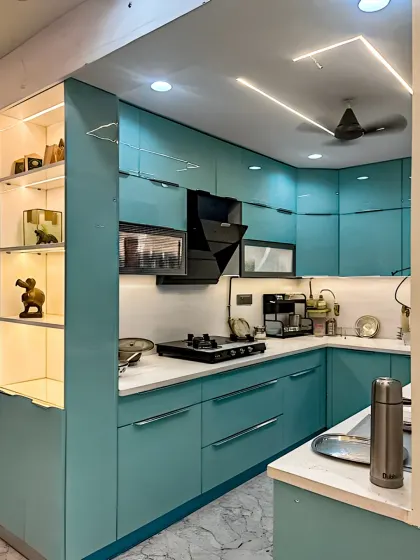 This modern kitchen showcases sleek, turquoise-colored cabinets with a glossy finish. A built-in display shelf with internal lighting adds a decorative touch, while the white countertop keeps the look fresh.
