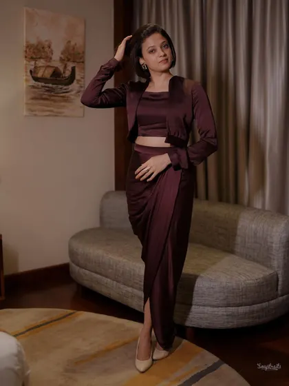 A full-length shot from a styled session, showing a contemporary draped outfit. The pose and indoor lighting are designed to create a chic and elegant mood for this fashion portrait.