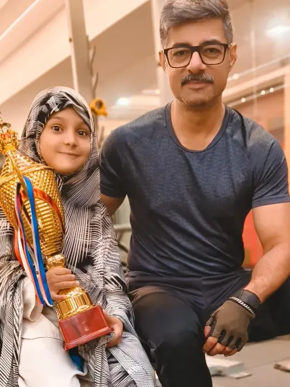 Another supporter celebrating with our young gold medalist. The whole community is proud of her achievement.