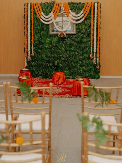 A simple yet profound backdrop for a pre-wedding ritual, created entirely from fresh coffee leaves sourced from the bride's family estate in Coorg. Garlands of marigold and tuberose add a traditional touch.